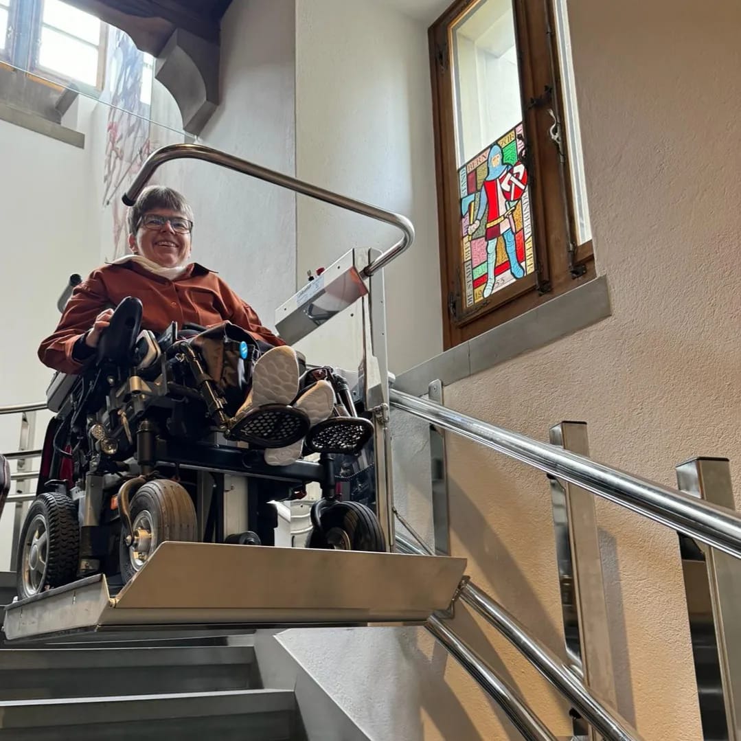 Simone Leuenberger im Elektrorollstuhl auf dem Treppenlift im Rathaus Bern